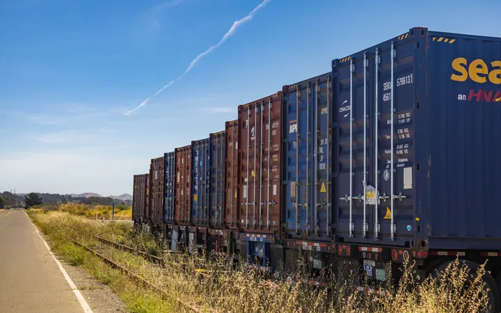 Freight train carrying shipping containers on railway tracks; illustrative stock photography.
